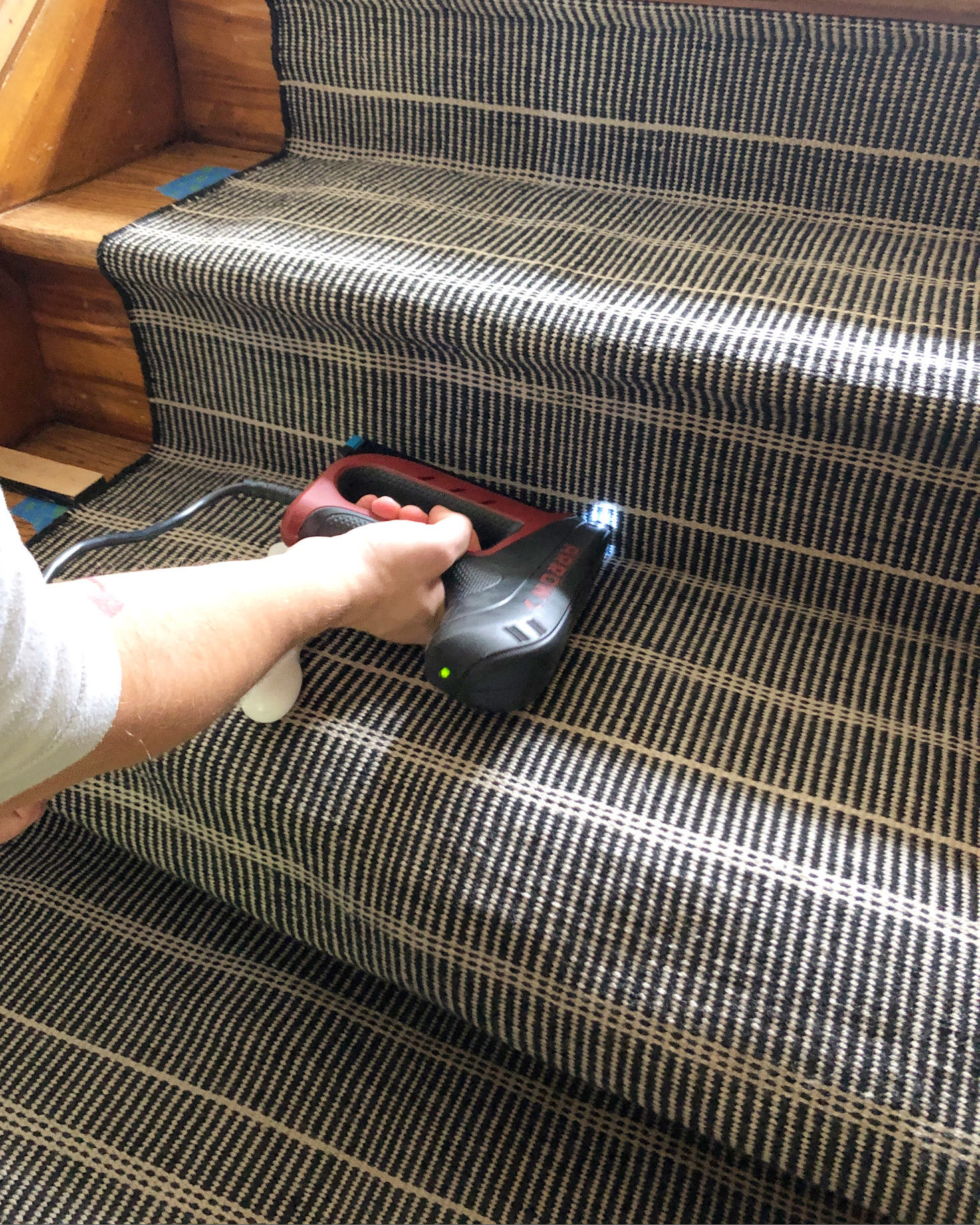 Using a staple gun to install a stair runner